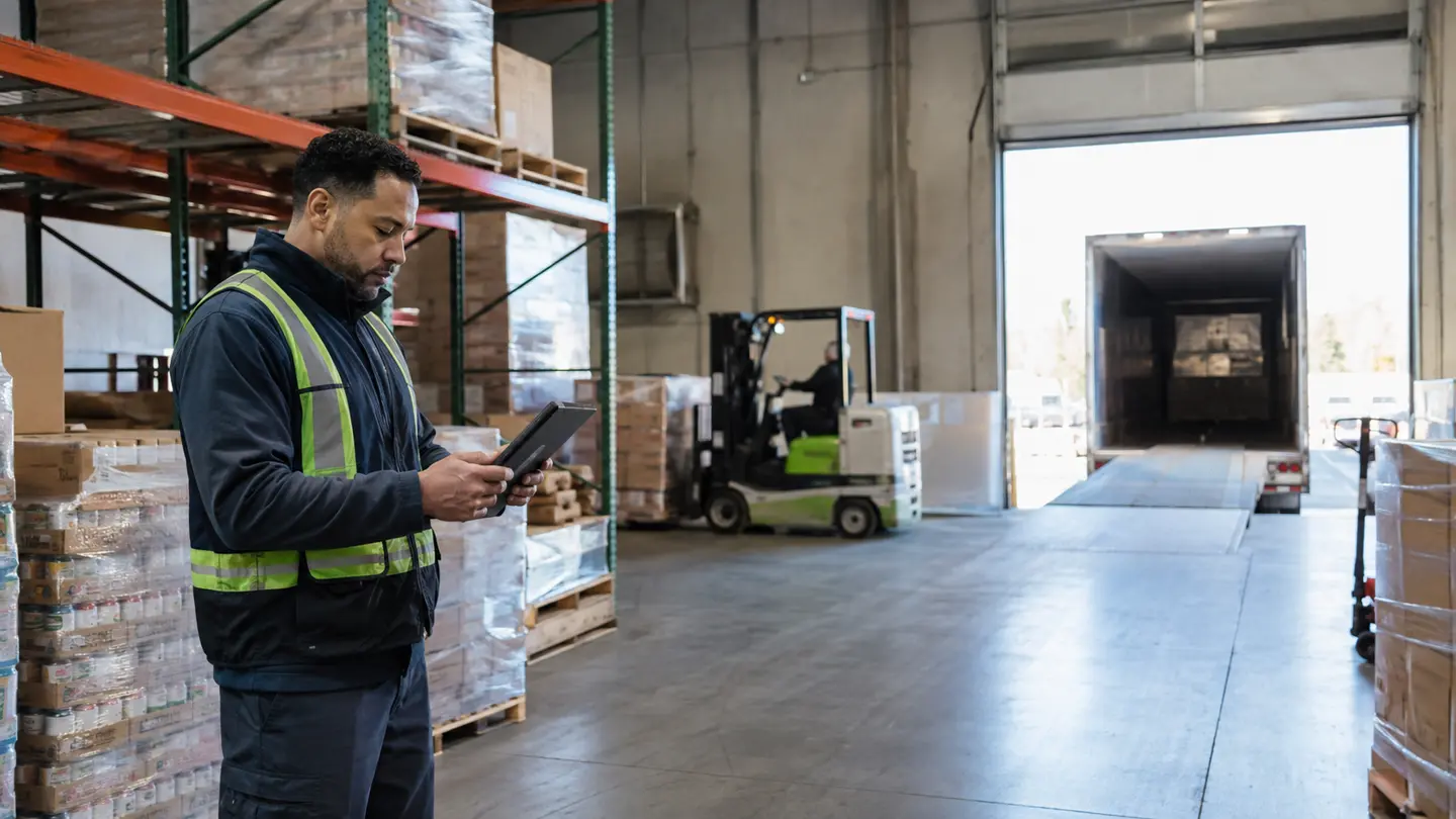 Warehouse operator reviewing an order near the loading bay